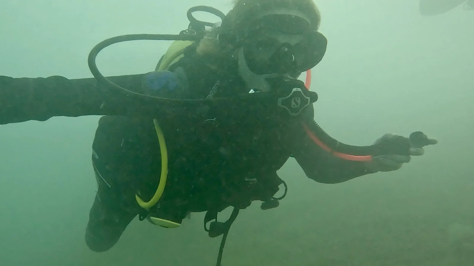 Open Water Diver im trüben Attersee mit Ronja und Mario Ein Taucher schwebt im grünlich-trüben Wasser des Attersees und übt ruhig mit Tauchgerät und Maske.
